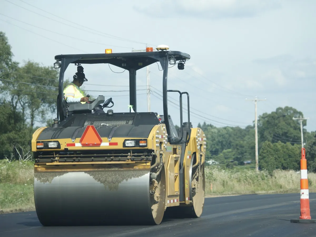 Road roller compacting a newly surfaced carriageway