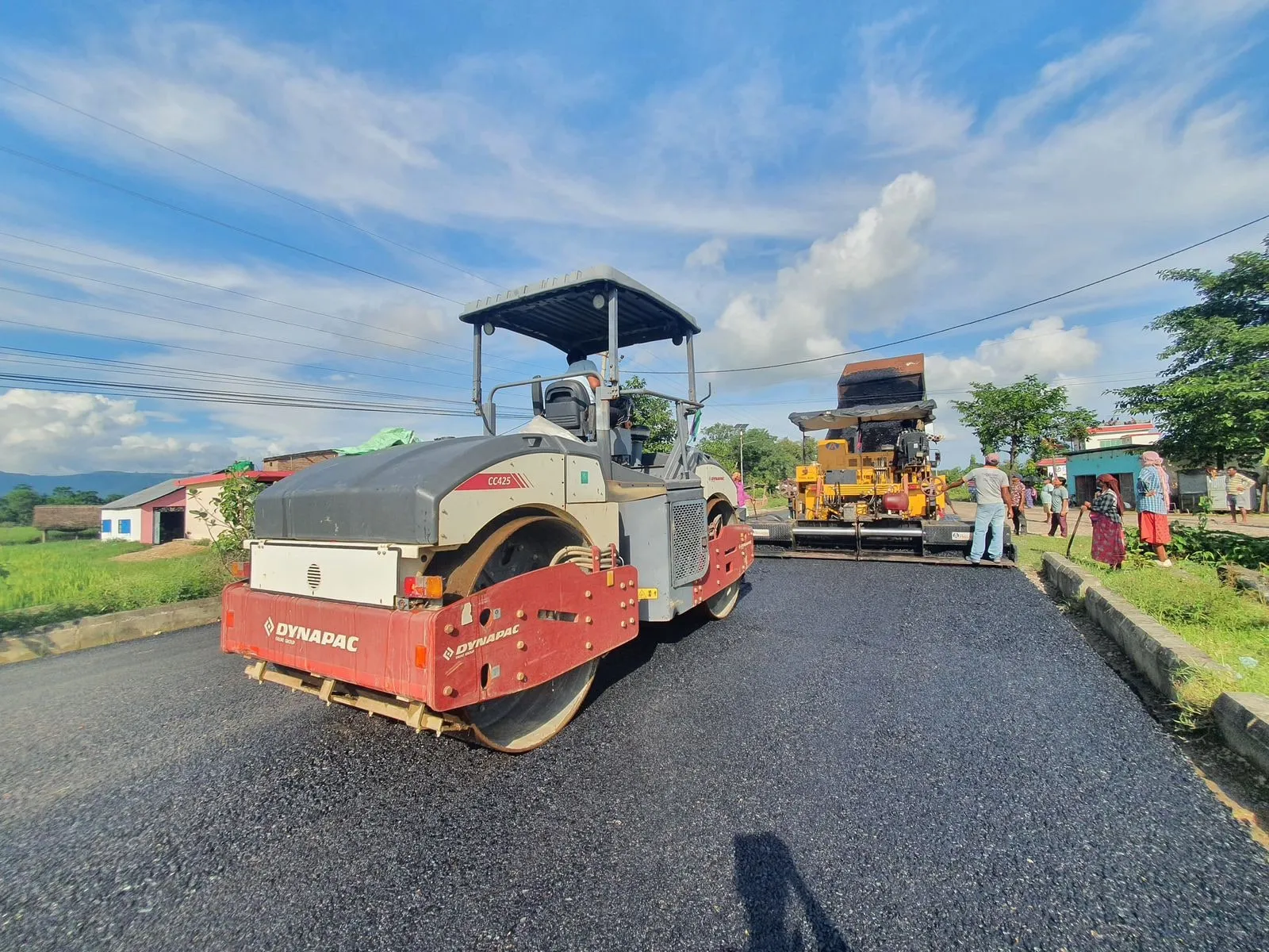 Road roller and paver working together on a fresh section of carriageway