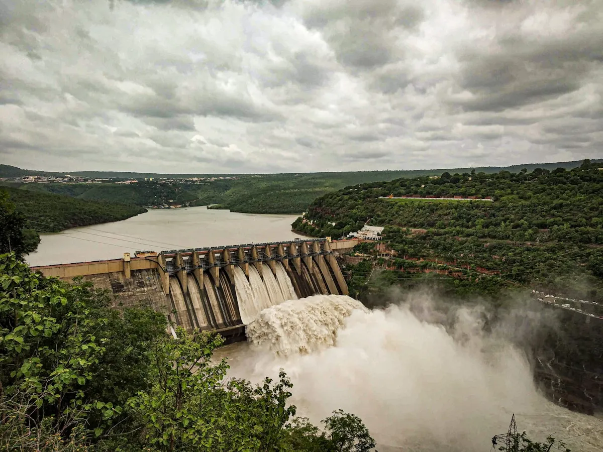 Water discharging through a dam spillway under heavy cloud