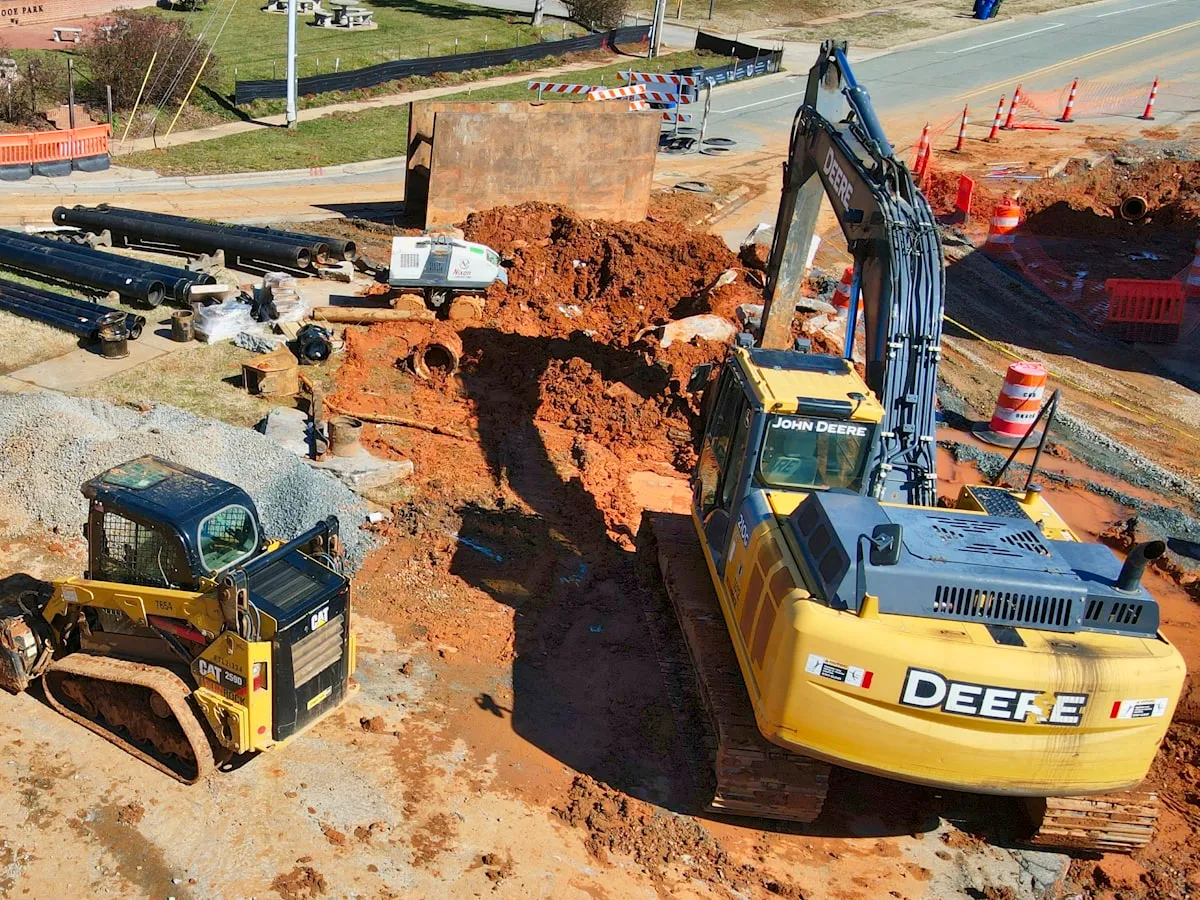 Excavator and loader moving earth on a highway earthworks section