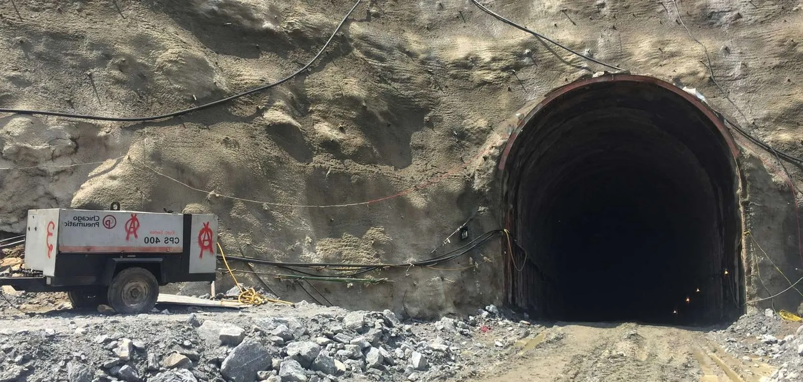 Inside the tunnel works, cabling and rock support visible at the portal