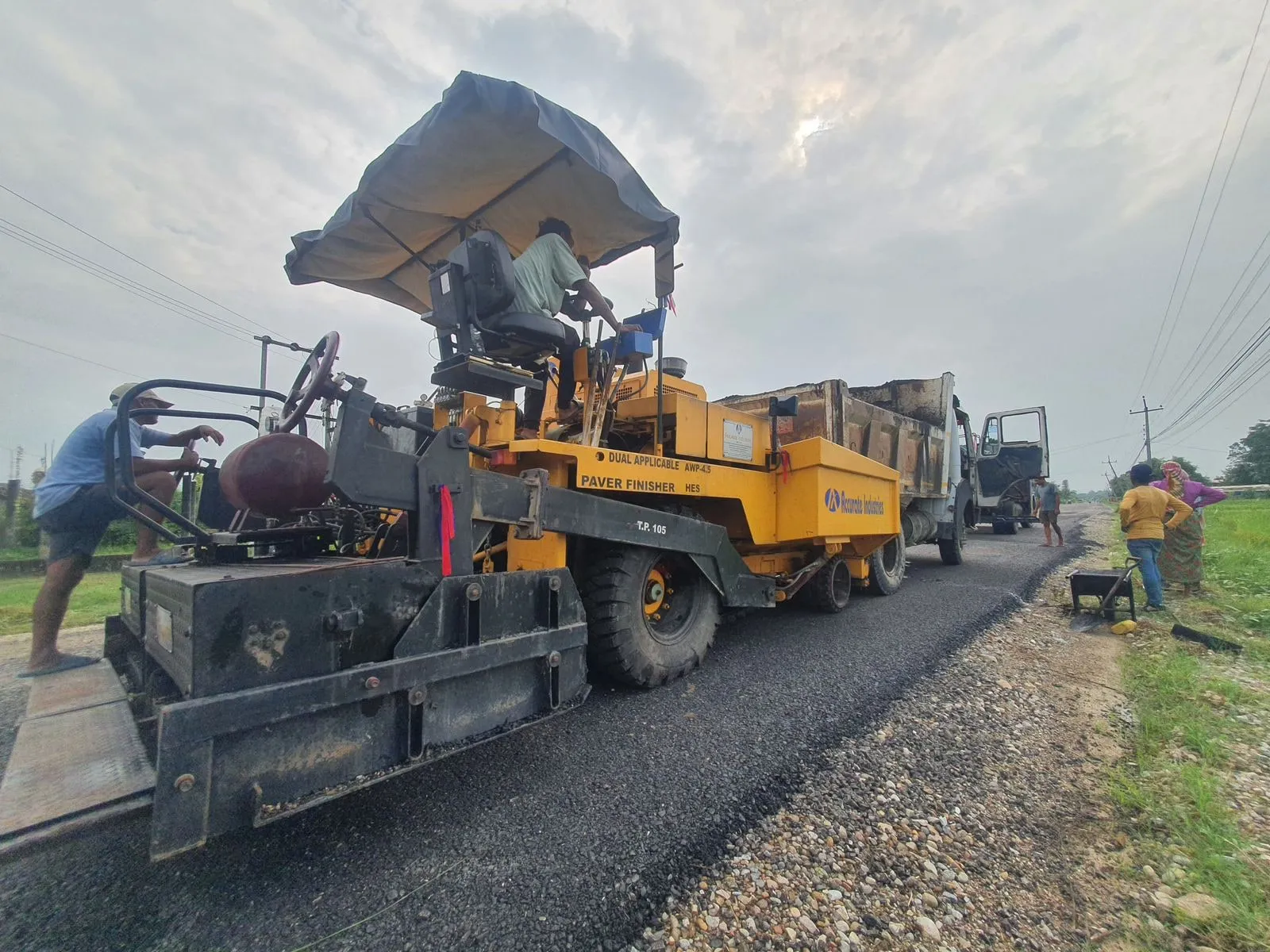 Asphalt paver laying a new surface on the Hulaki Rajmarga highway package
